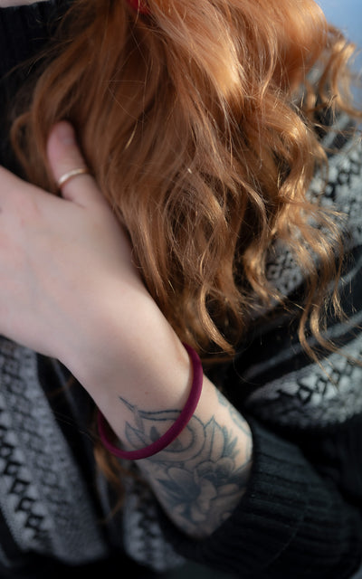 Bracelet contemporain aubergine sur bras avec tattoos