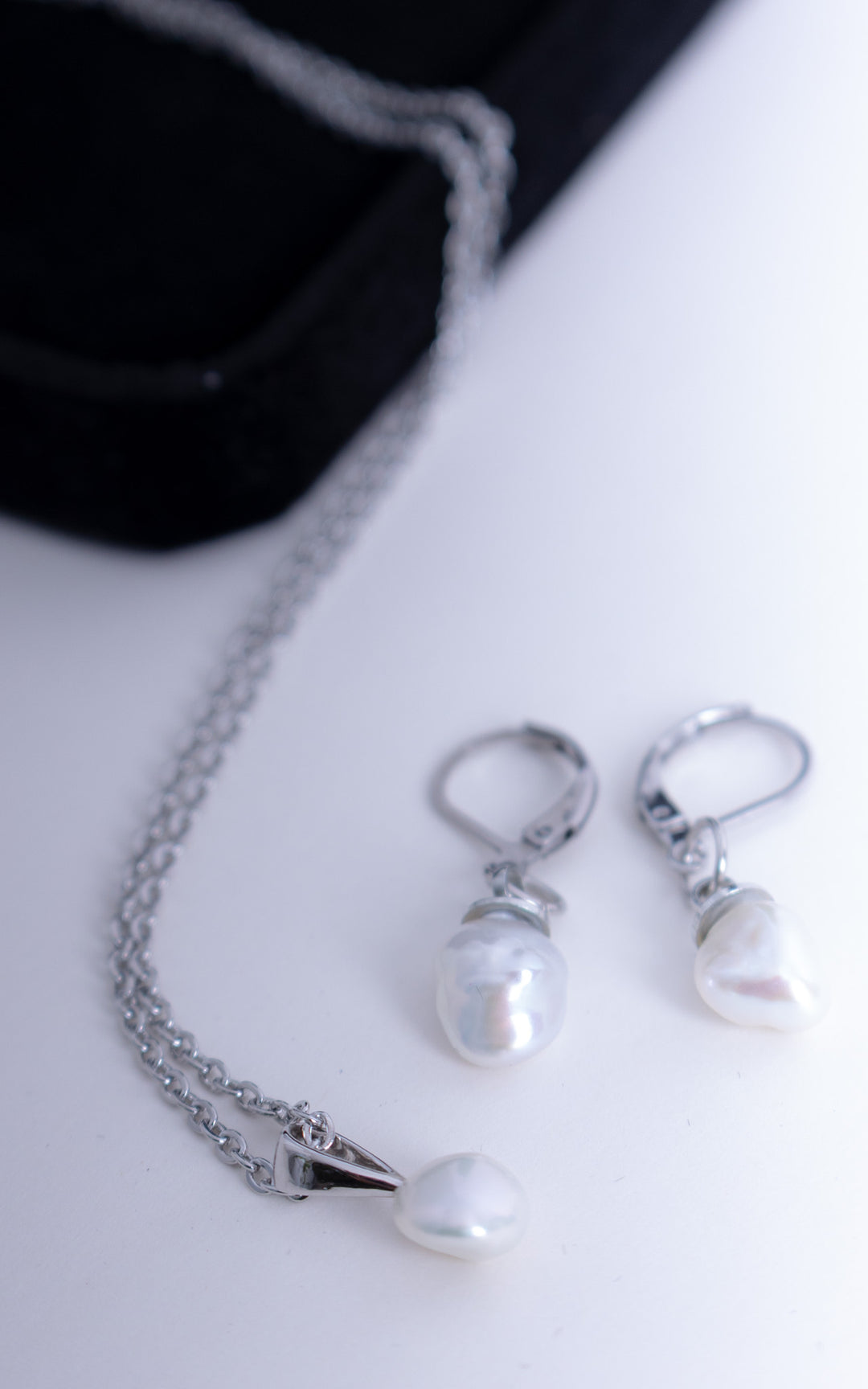 Collier fin avec pendentif perle baroque blanche et boucles d’oreilles dormeuses assorties en acier inoxydable, bijou délicat sur fond clair