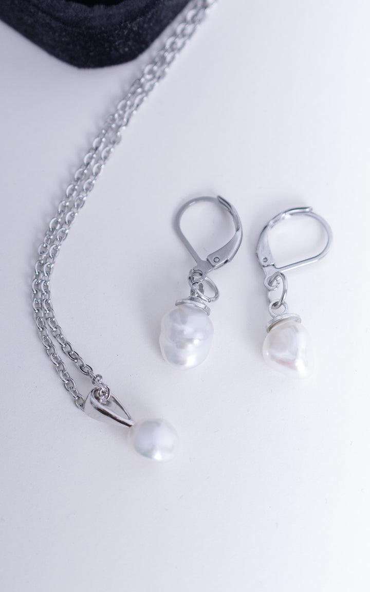 Ensemble collier et boucles d’oreilles en acier inoxydable avec perles baroques blanches, bijou minimaliste et élégant sur fond clair