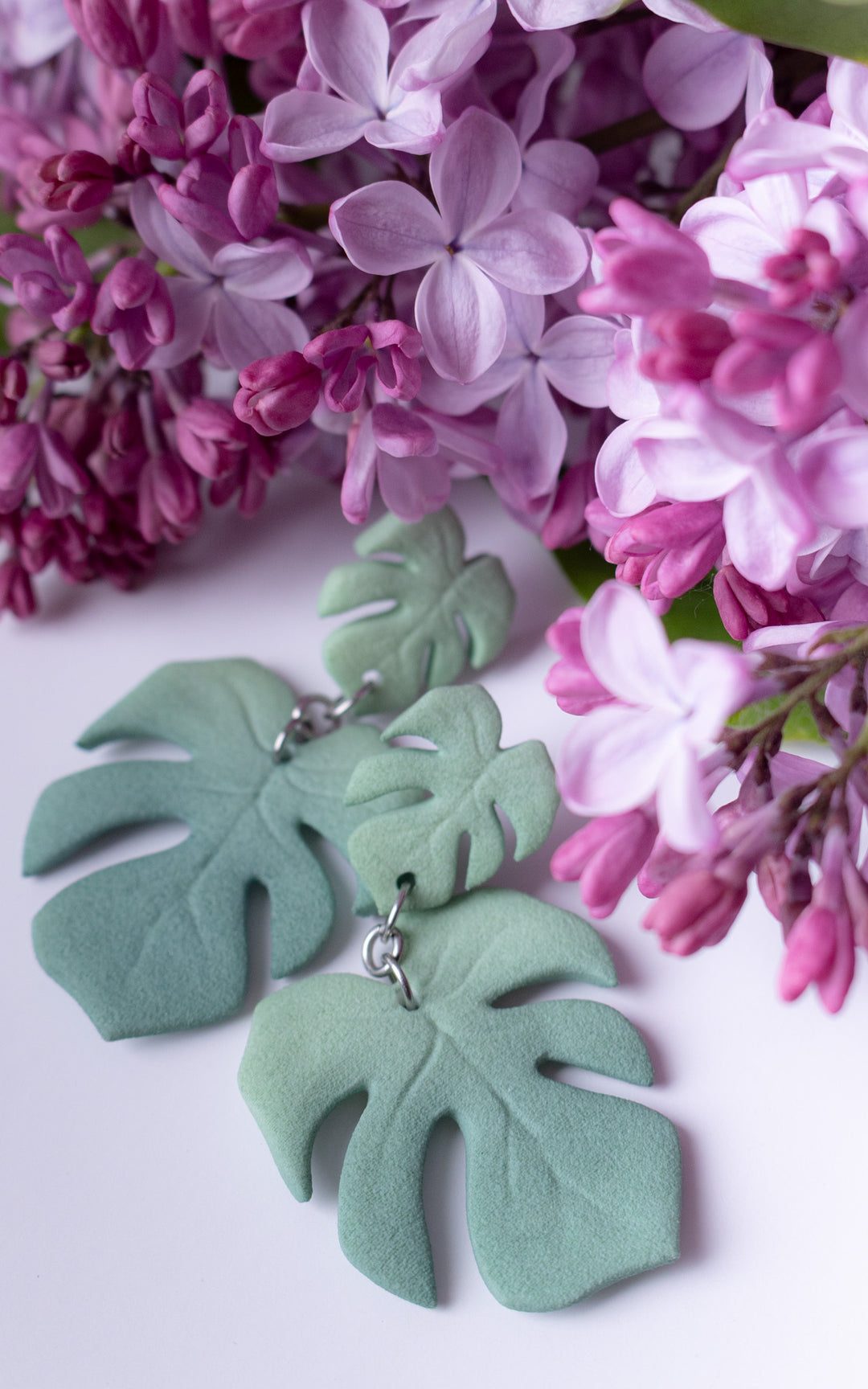 Boucles d’oreilles MAUI Monstera vert sauge dans une ambiance florale lilas